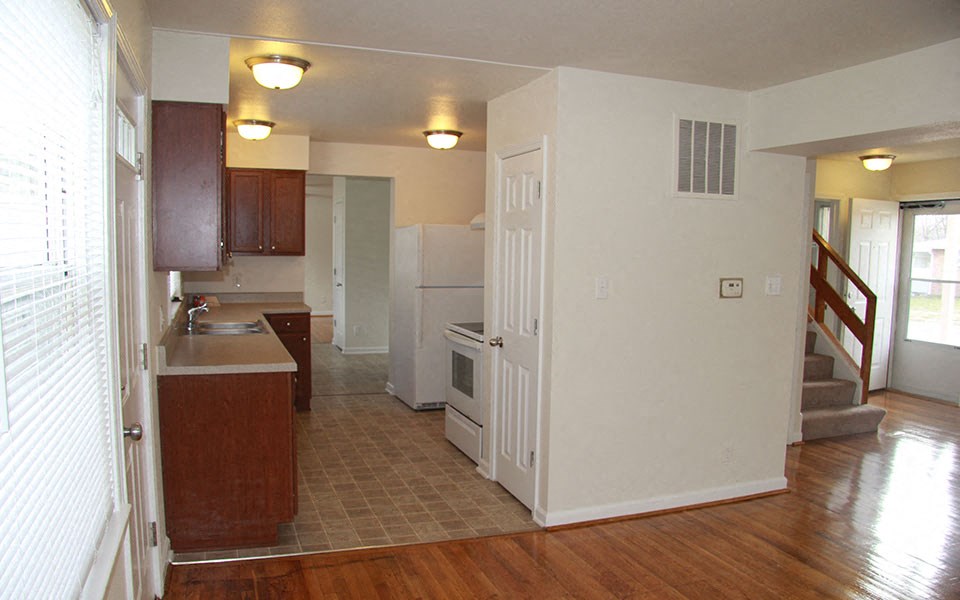 an empty kitchen with a refrigerator and a sink