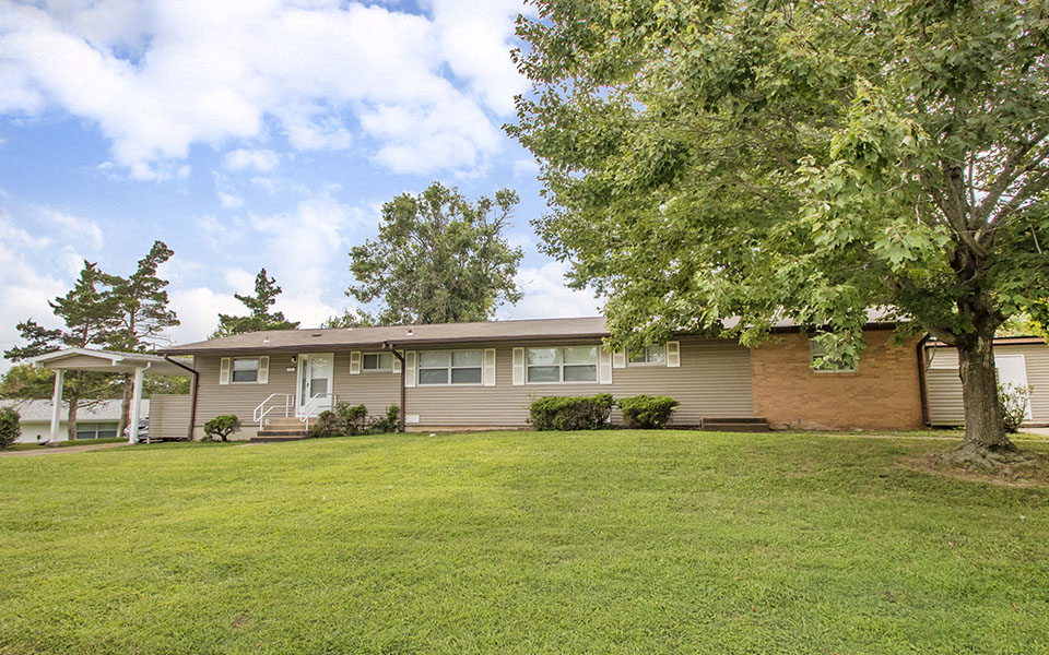 the exterior of a house with a large grassy yard
