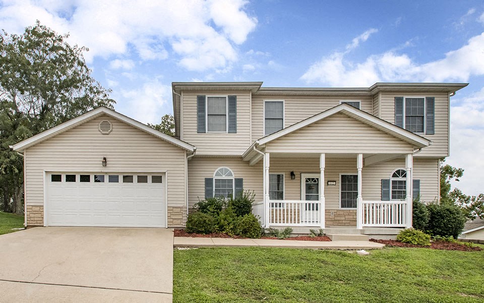 a beige house with a white garage door