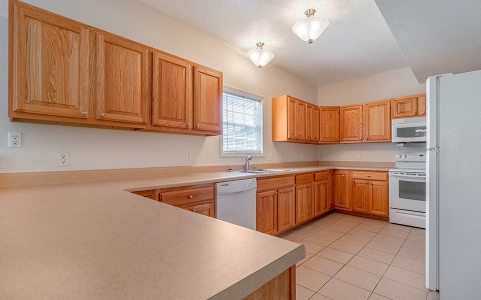 a kitchen with wooden cabinets and white appliances