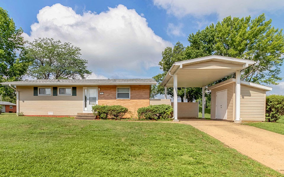 a small house with a dirt road in front of it