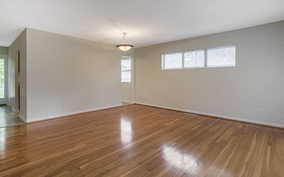 an empty living room with a hard wood floor