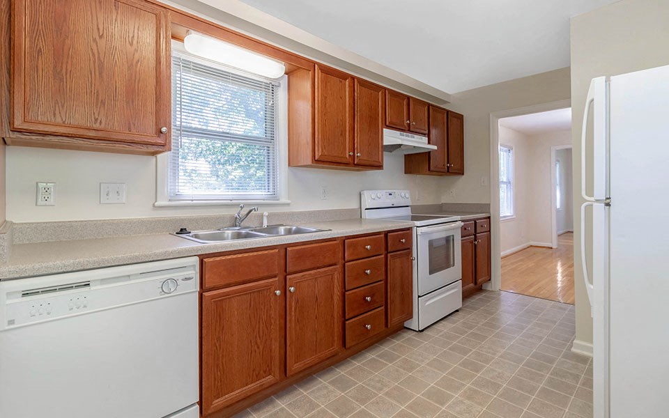 a kitchen with wooden cabinets and a dishwasher and a sink