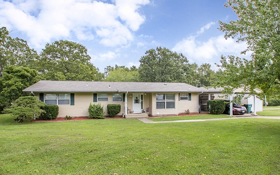 a house with a lawn and a car parked in front of it