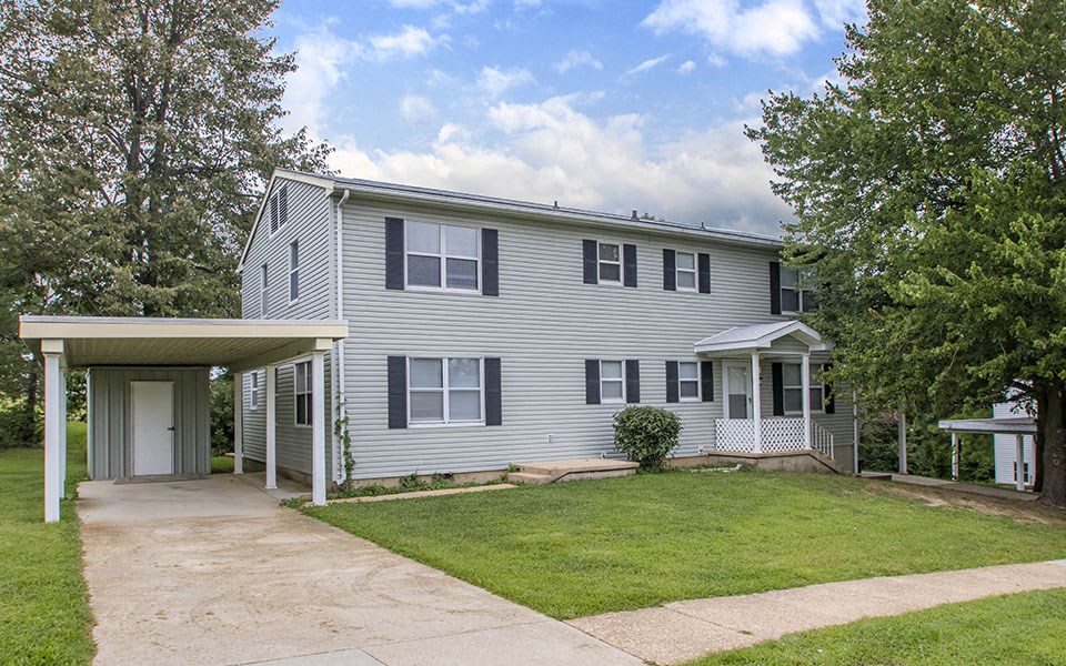 a white house with a lawn and a driveway