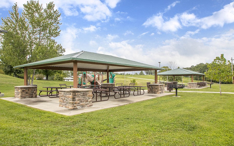 a pavilion with picnic tables in a park