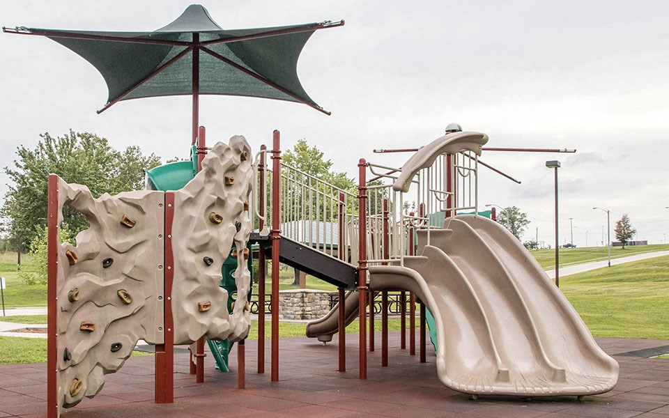 a playground with a bunch of slides and umbrellas