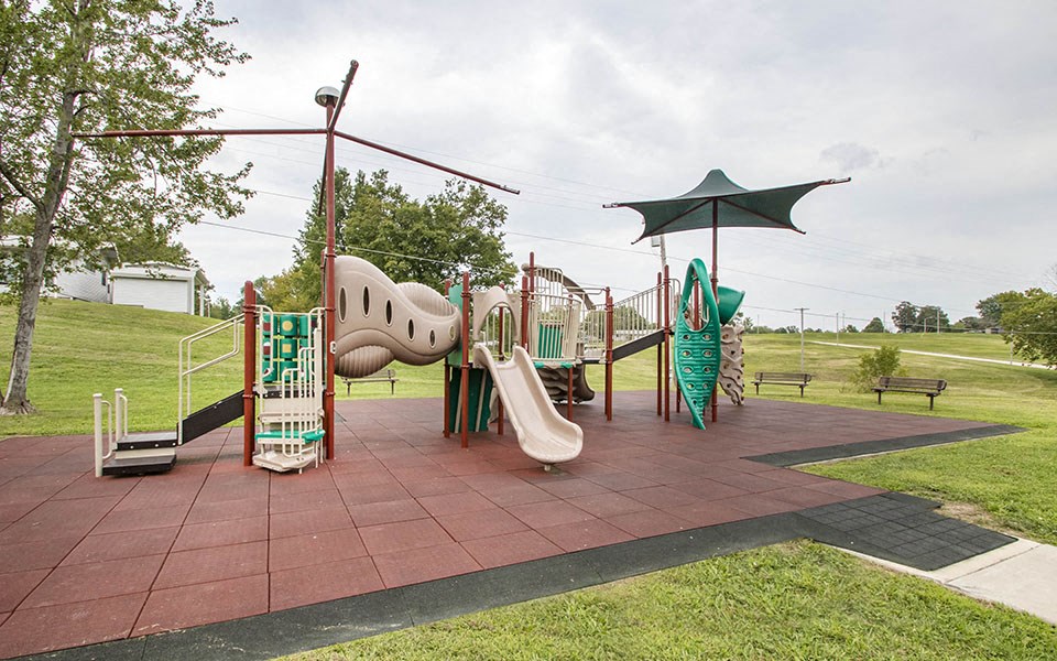 a playground with toys and an umbrella in a park
