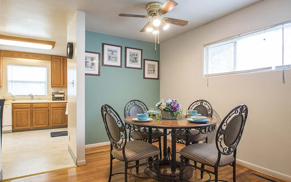 a dining room with a table and chairs and a ceiling fan