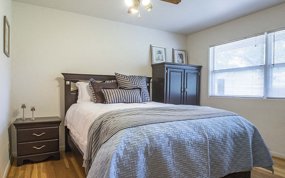 a bedroom with a bed and a dresser and a window