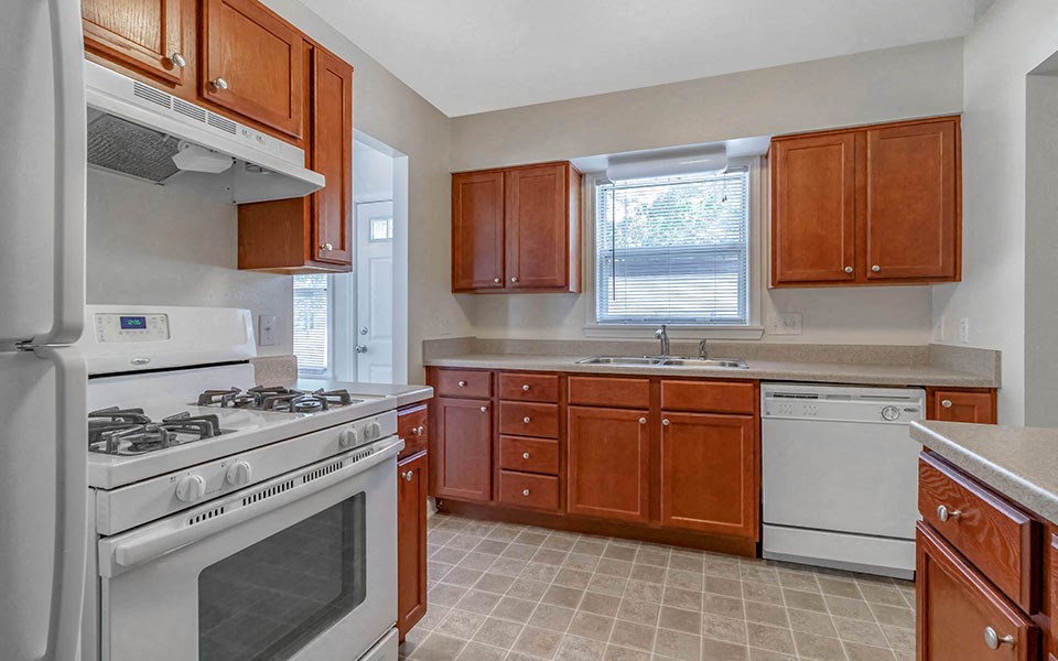 a kitchen with white appliances and wooden cabinets