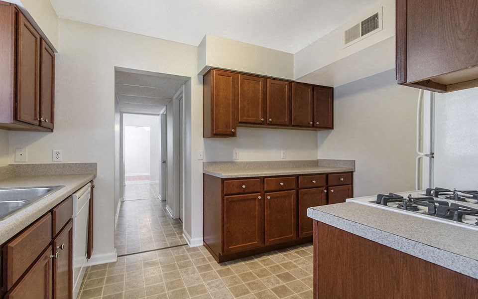 a kitchen with wooden cabinets and a stove and a sink