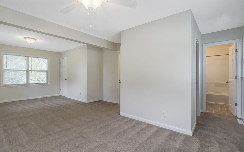 an empty living room with a door to a closet
