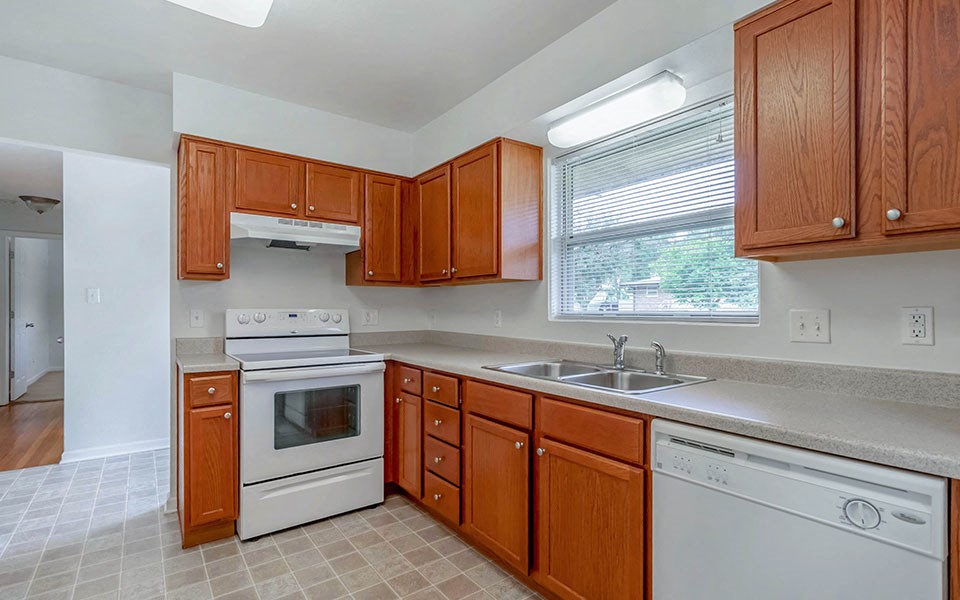 a kitchen with white appliances and wooden cabinets