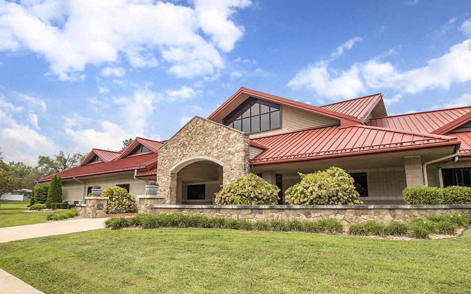 a house with a red roof and a green lawn