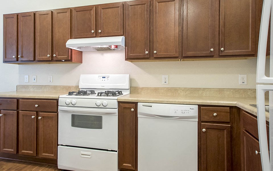 a kitchen with white appliances and wooden cabinets