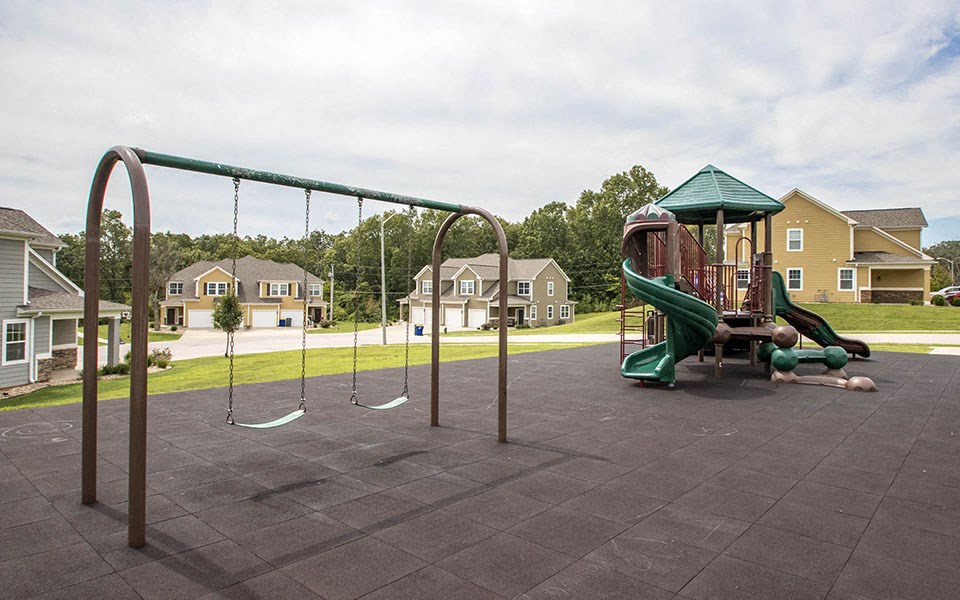 a playground with a swing set in a park