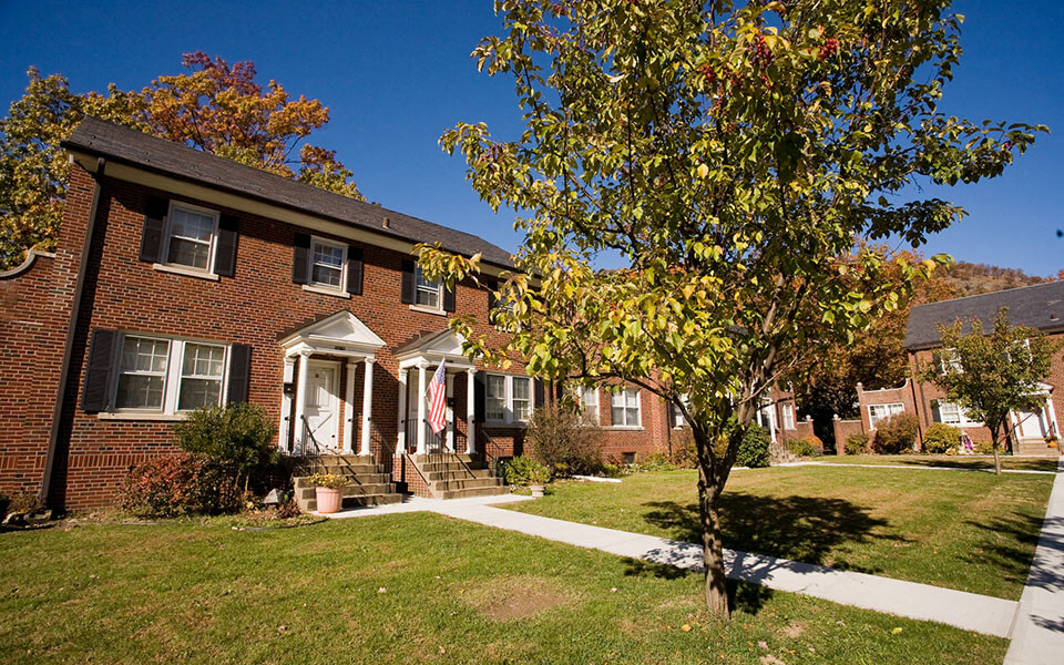 a red brick house with a tree in front of it