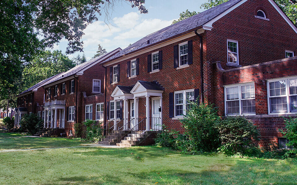 a large red brick building with grass and trees
