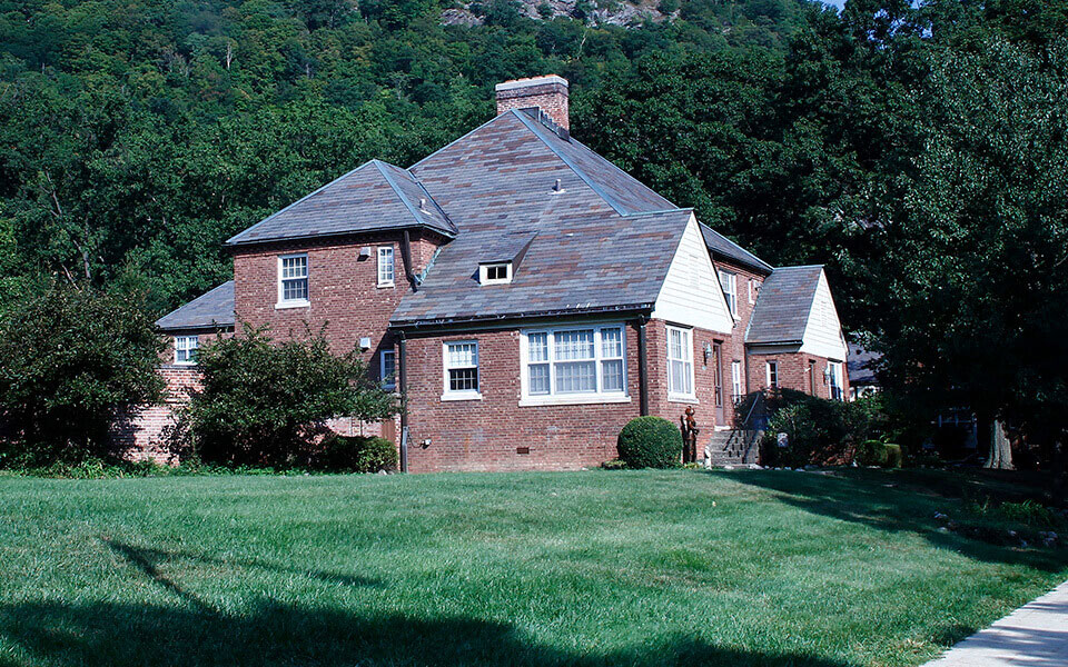 a large brick house with a yard and trees
