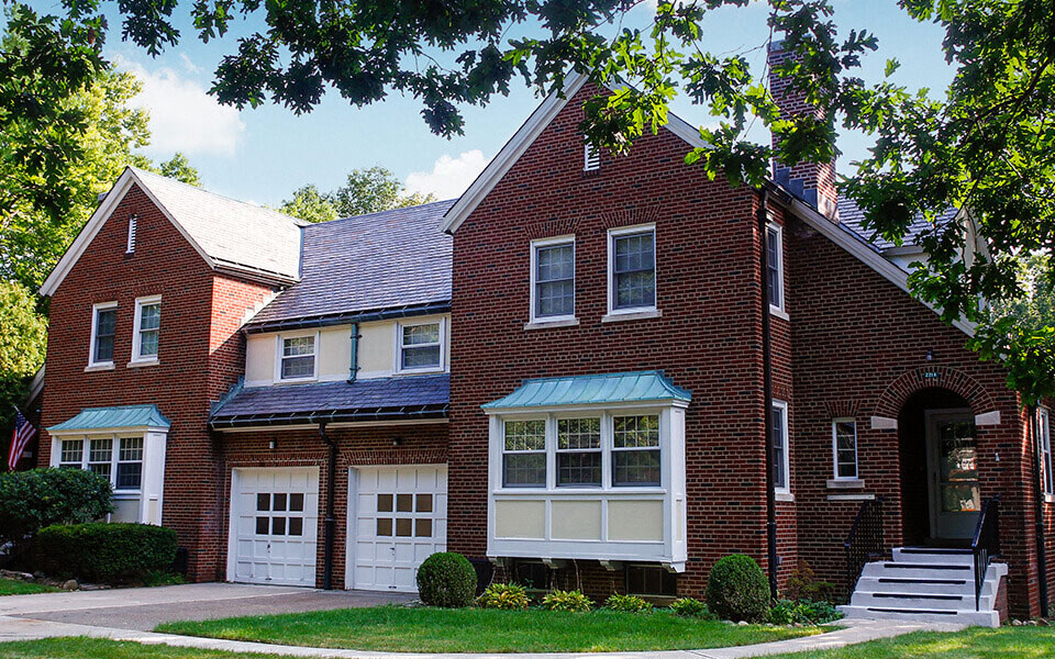 a red brick house with white garage doors