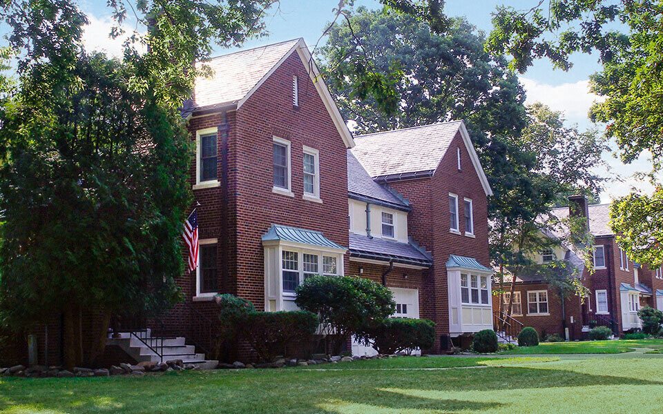 a red brick house with an flag in front of it
