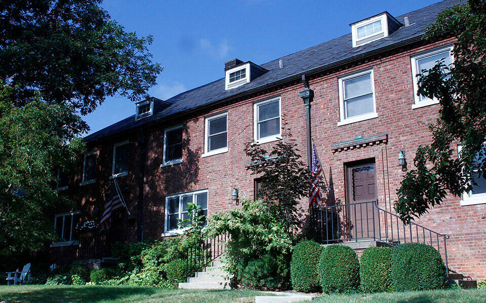 a red brick house with a flag in front of it