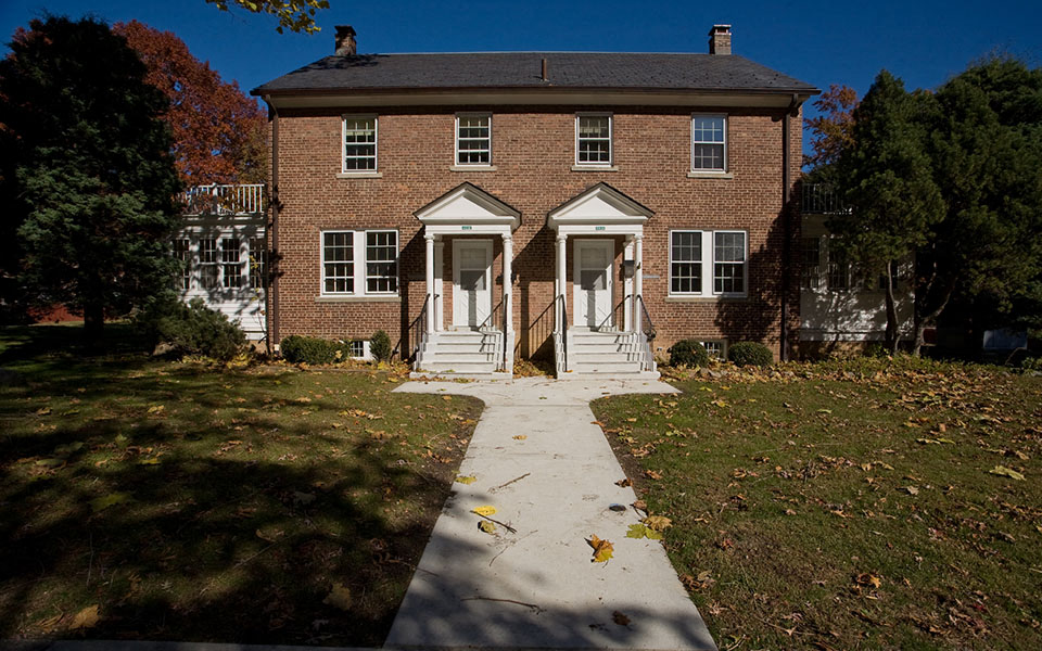 an old brick house with a sidewalk in front of it