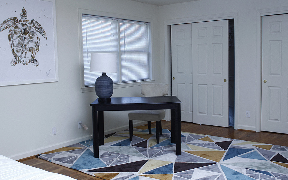 a bedroom with a desk and a chair and a window