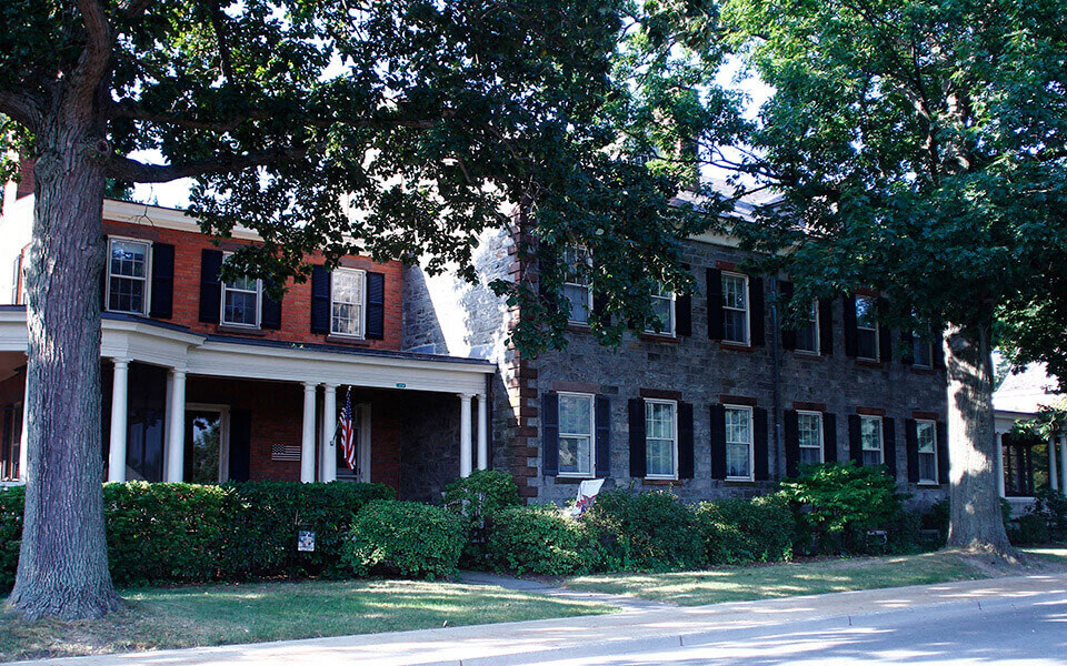 a large brick house with a tree in front of it