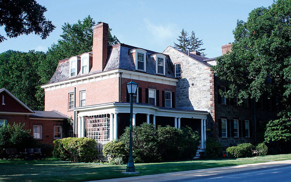 a large brick house with a porch and a street light