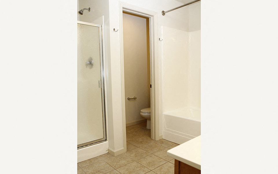 an empty bathroom with a shower and a toilet