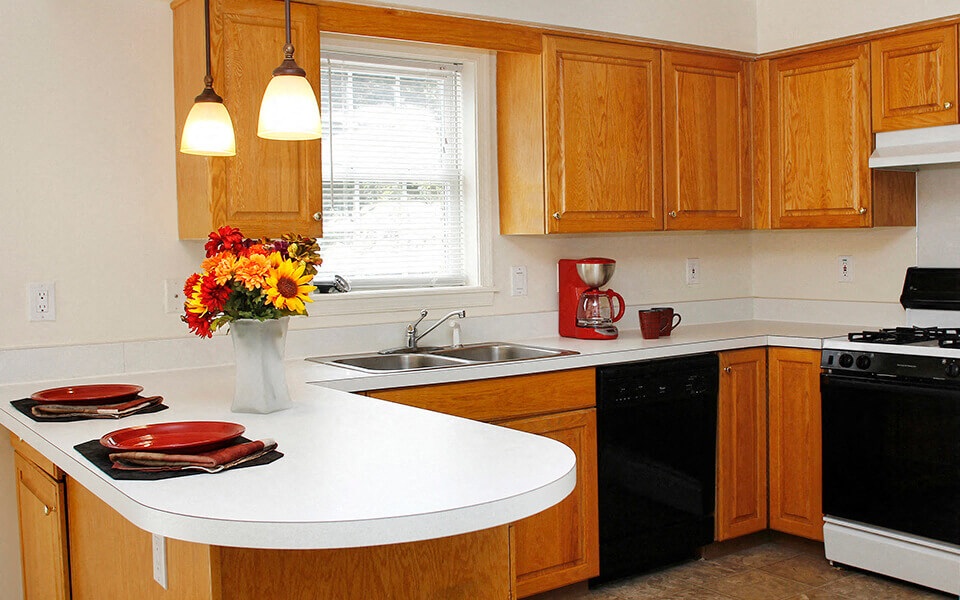 a kitchen with a white counter top and a sink