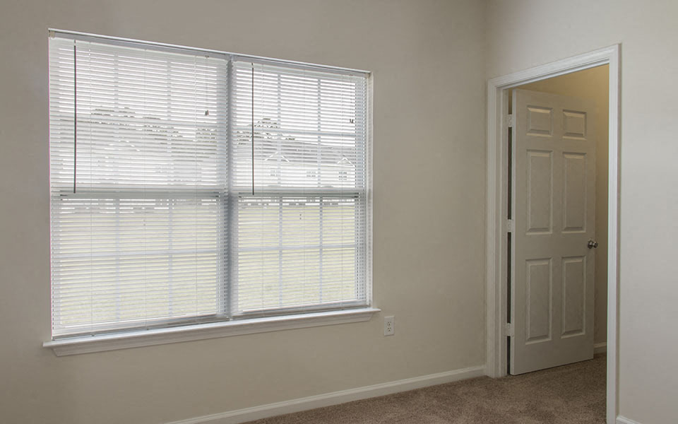 a room with a large window and a white door