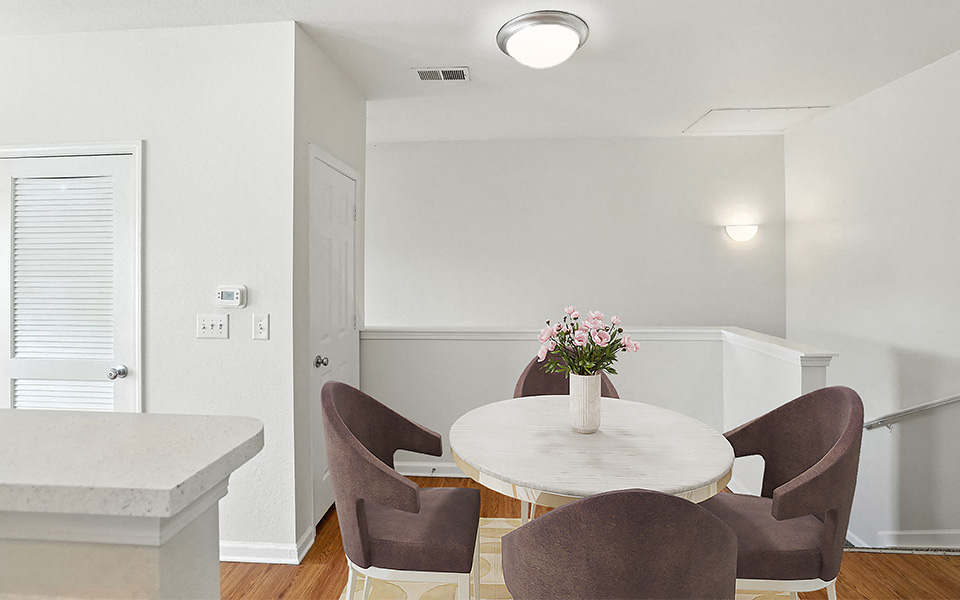 A dining room with a round table and chairs.