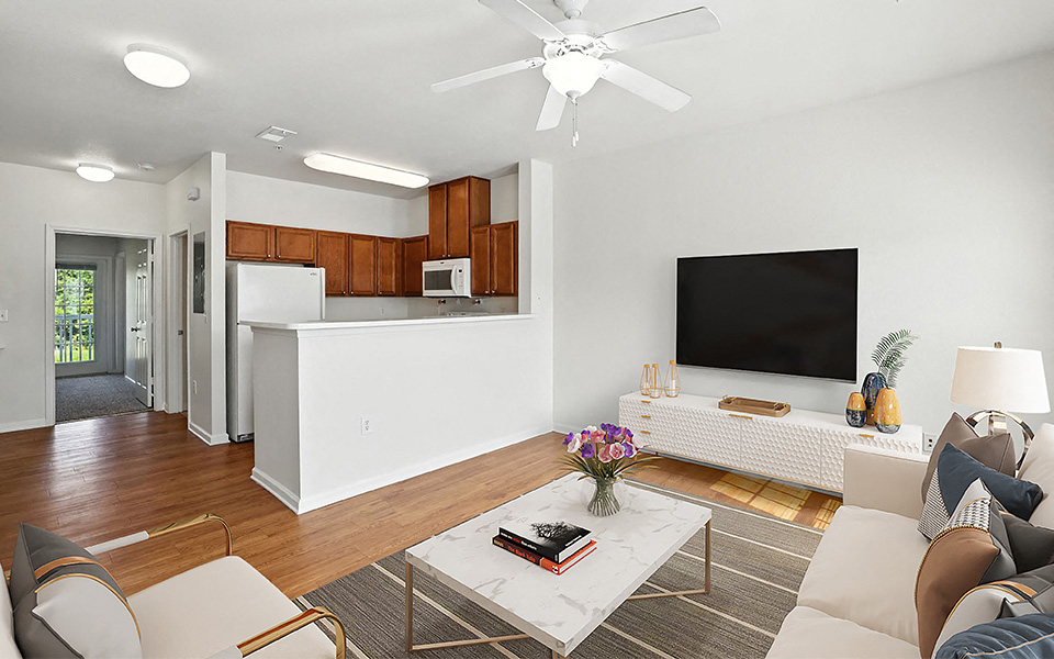 A living room with a white couch and a television on the wall.