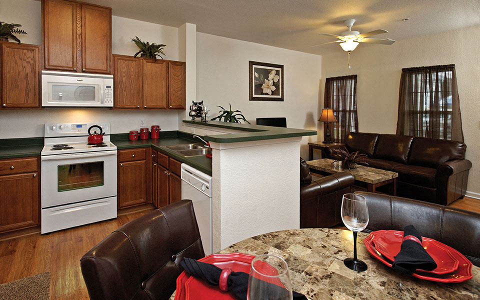 a kitchen and living room with a table and chairs