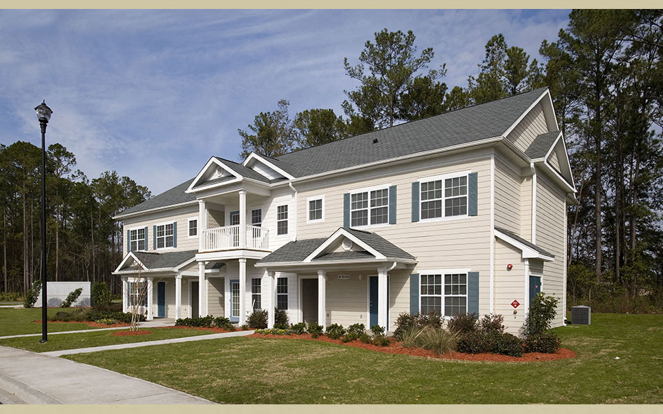 a large white house with a porch and a lawn