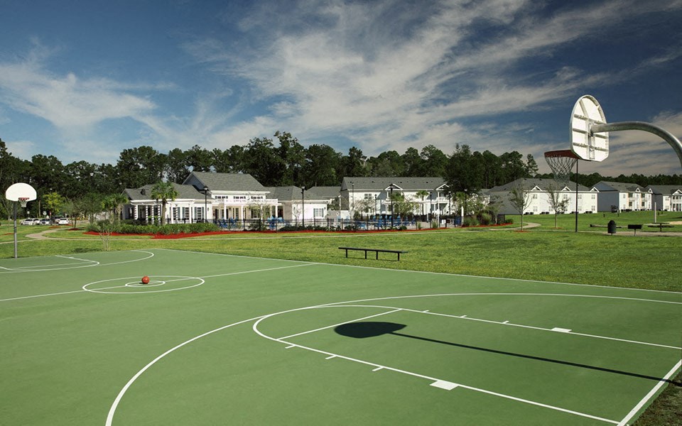 a basketball court in front of a row of houses