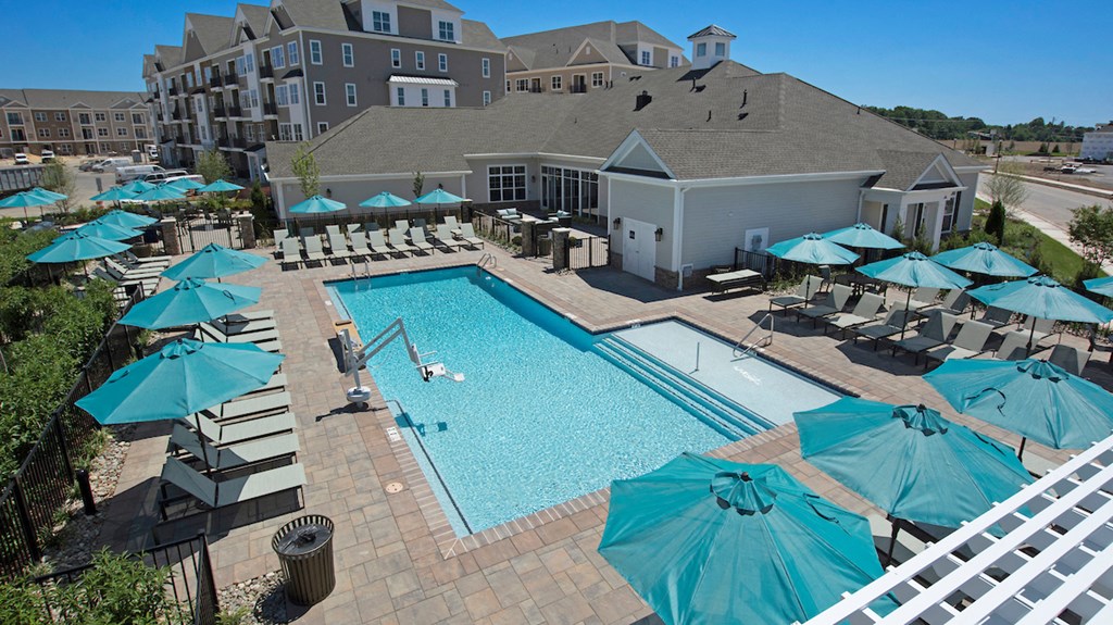an aerial view of a swimming pool with umbrellas and a resort style pool