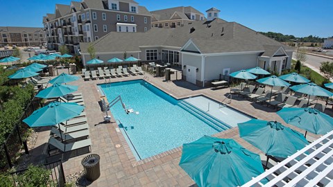 an aerial view of a swimming pool with umbrellas and a resort style pool