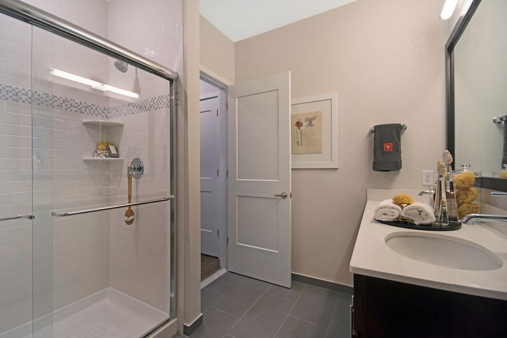 a bathroom with a shower and a sink and a mirror