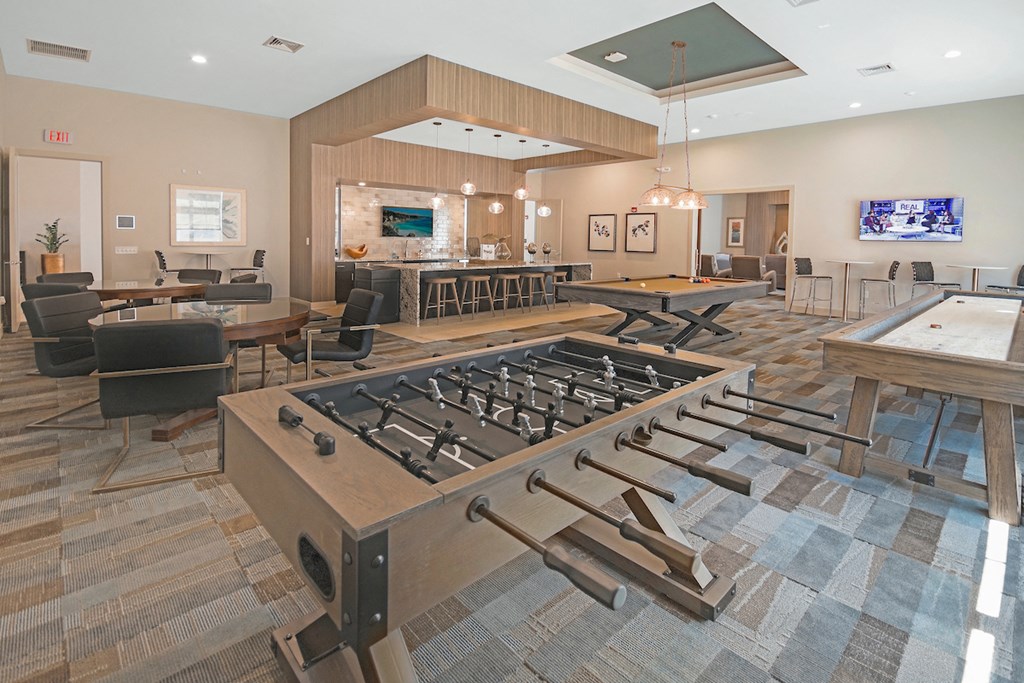 a game room with a foosball table and tables