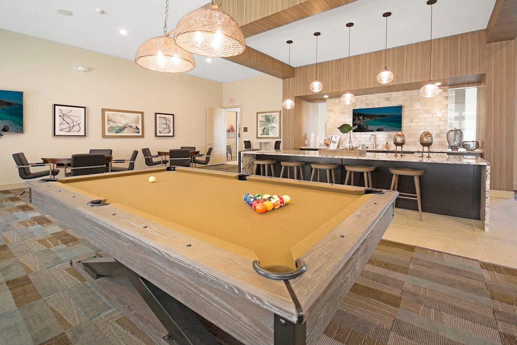 a pool table in a clubhouse with a bar