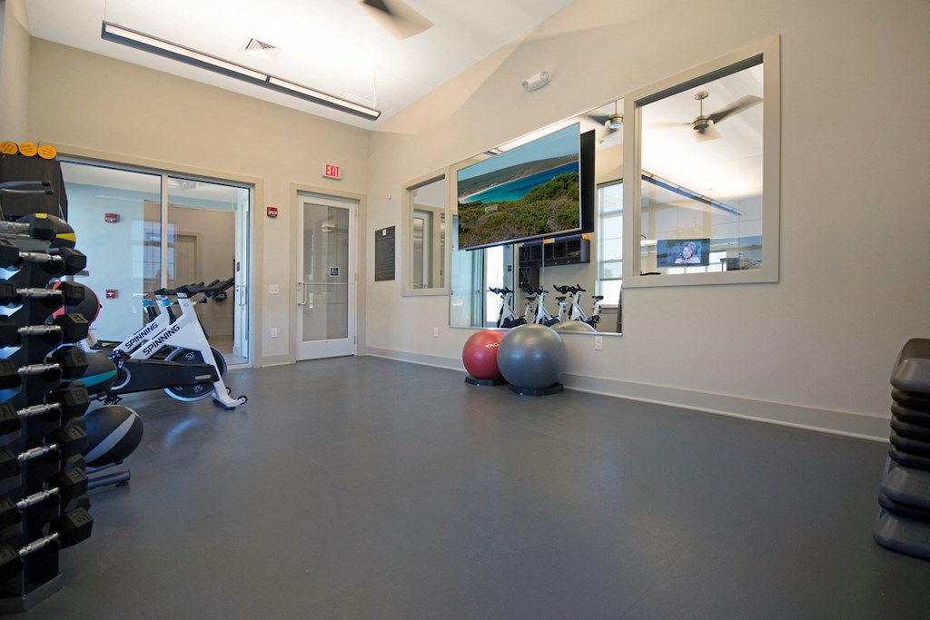 a gym with weights and a tv on the wall