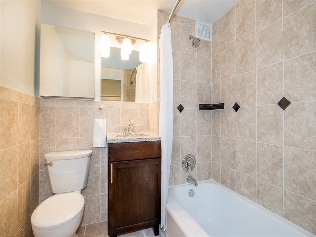 a bathroom with a toilet and a tub and a sink