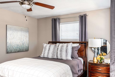 a bedroom with a bed and a ceiling fan