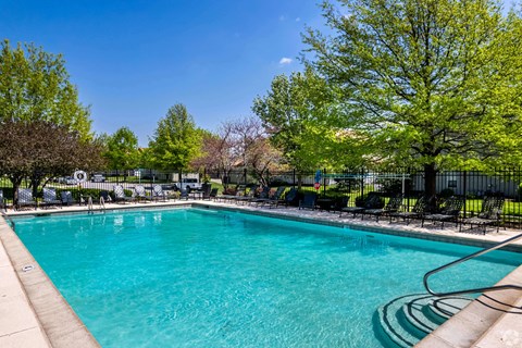 a swimming pool with trees and a fence around it