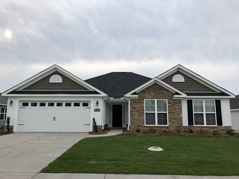 A house with a white garage door and a brown roof.