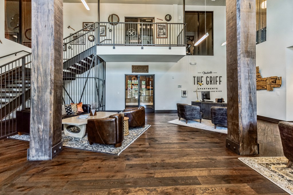 a living room with wood floors and a staircase
